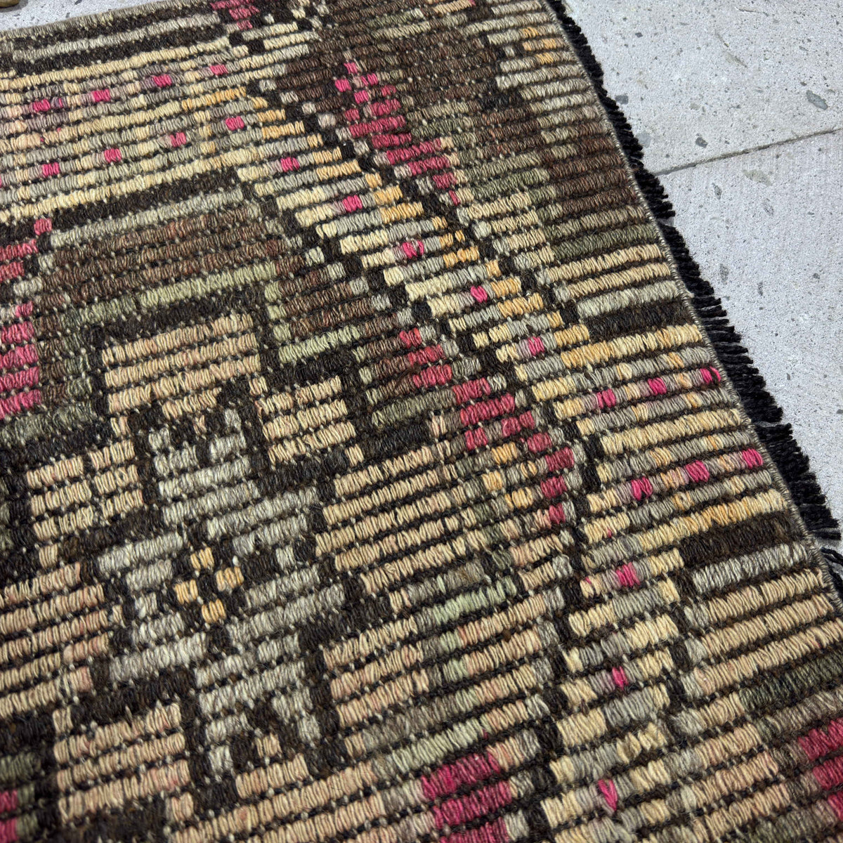 Close-up of the pink vintage Turkish kilim rug showing traditional details, hand-knotted weave, wool and cotton and low pile.