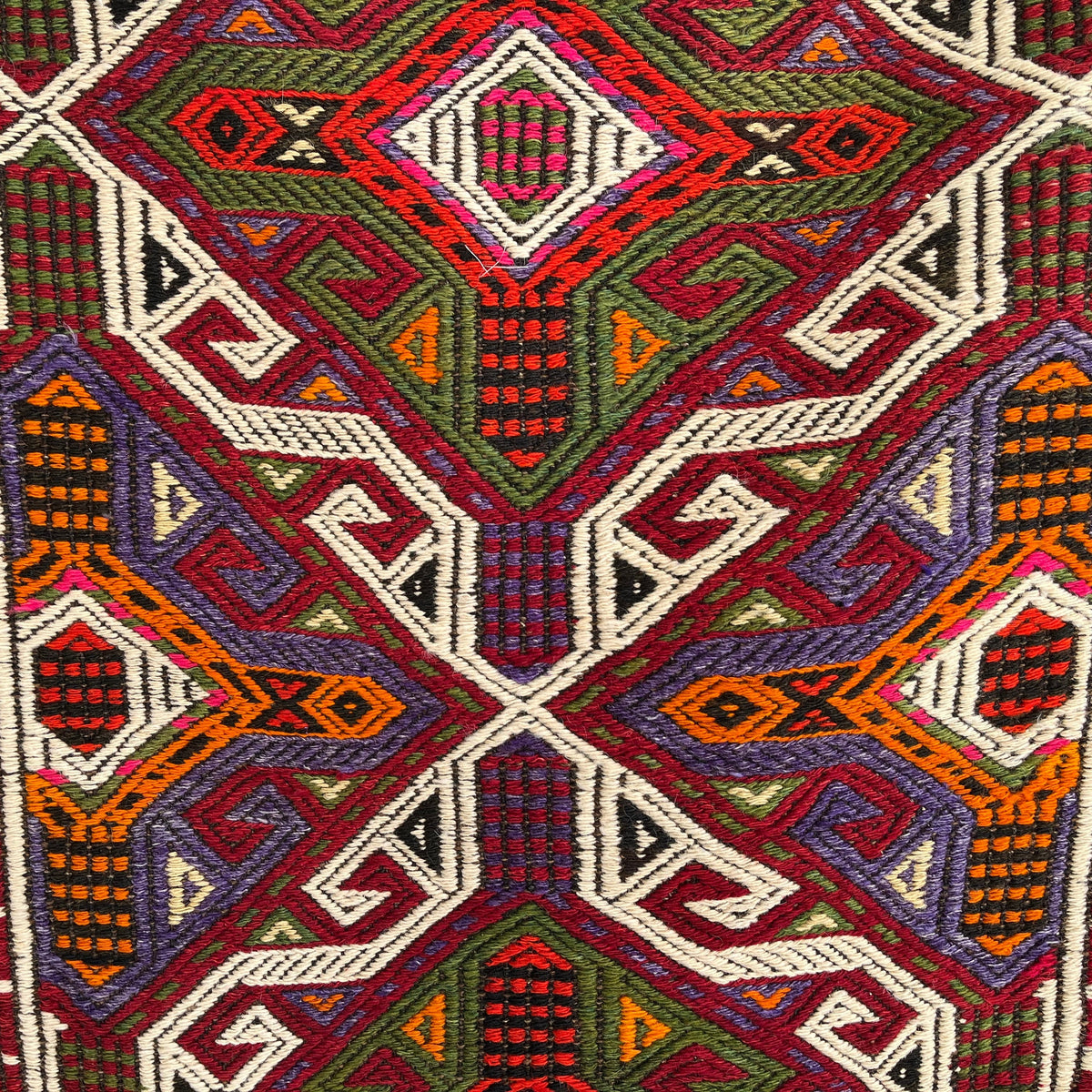 Close-up of the red vintage Turkish kilim rug showing traditional details, flatweave construction, wool and cotton and low pile.