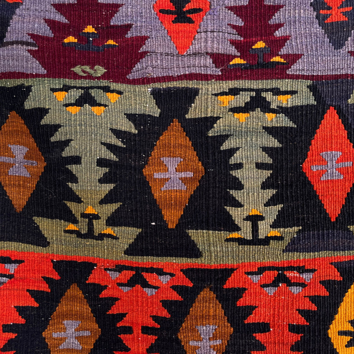 Close-up of the red vintage Turkish kilim rug showing traditional details, flatweave construction, wool and cotton and low pile.