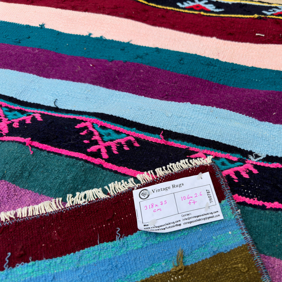 Close-up of the pink vintage Turkish kilim runner rug showing striped details, flatweave construction, wool and cotton and low pile.