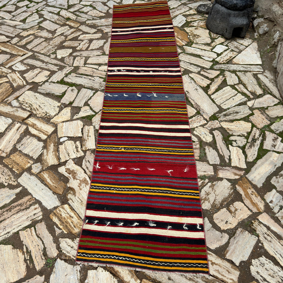 Red 2' x 10' vintage Turkish kilim runner rug in wool and cotton, shown on the floor.