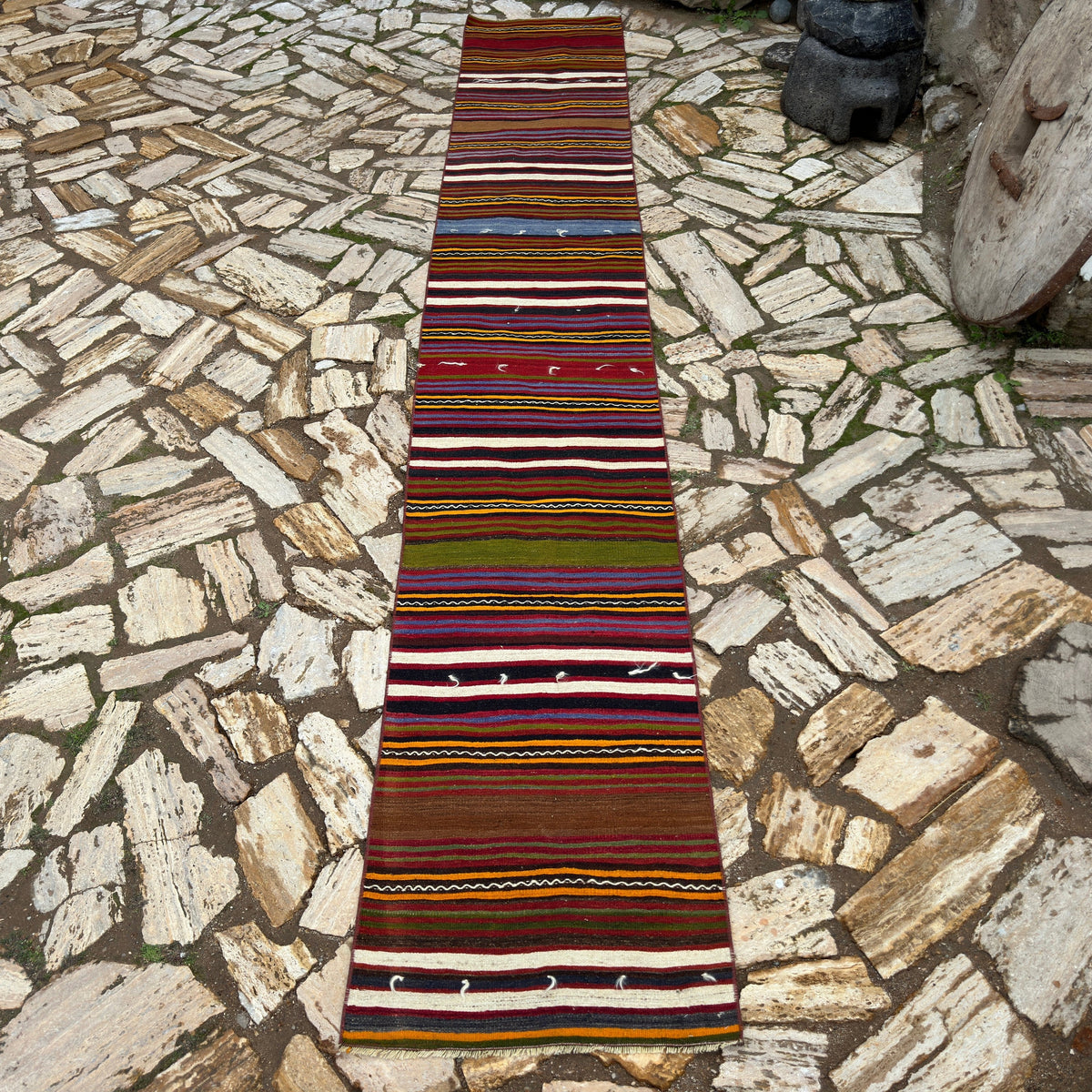 Red 2' x 13' vintage Turkish kilim runner rug in wool and cotton, shown on the floor.