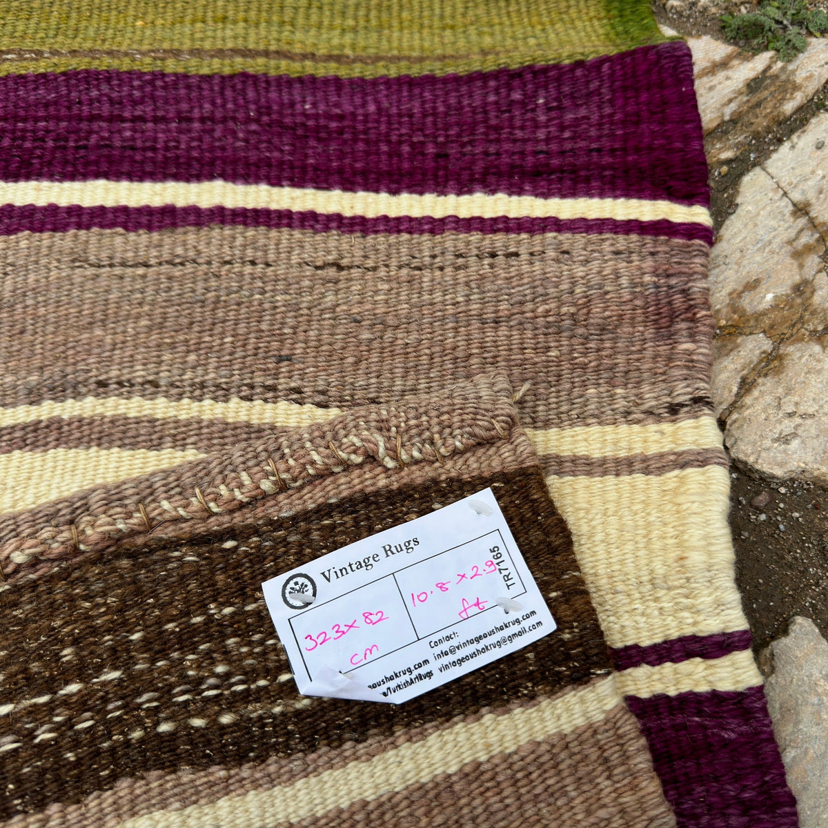 Close-up of the green vintage Turkish kilim runner rug showing striped details, flatweave construction, wool and cotton and low pile.
