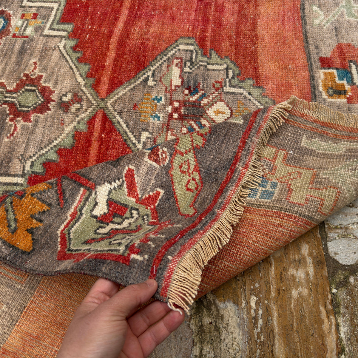Close-up of the red vintage Turkish medallion carpet showing medallion details, hand-knotted weave, wool and low pile.