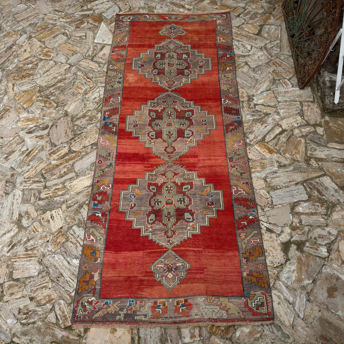 Red 5' x 12' vintage Turkish medallion carpet in wool, shown on the floor.