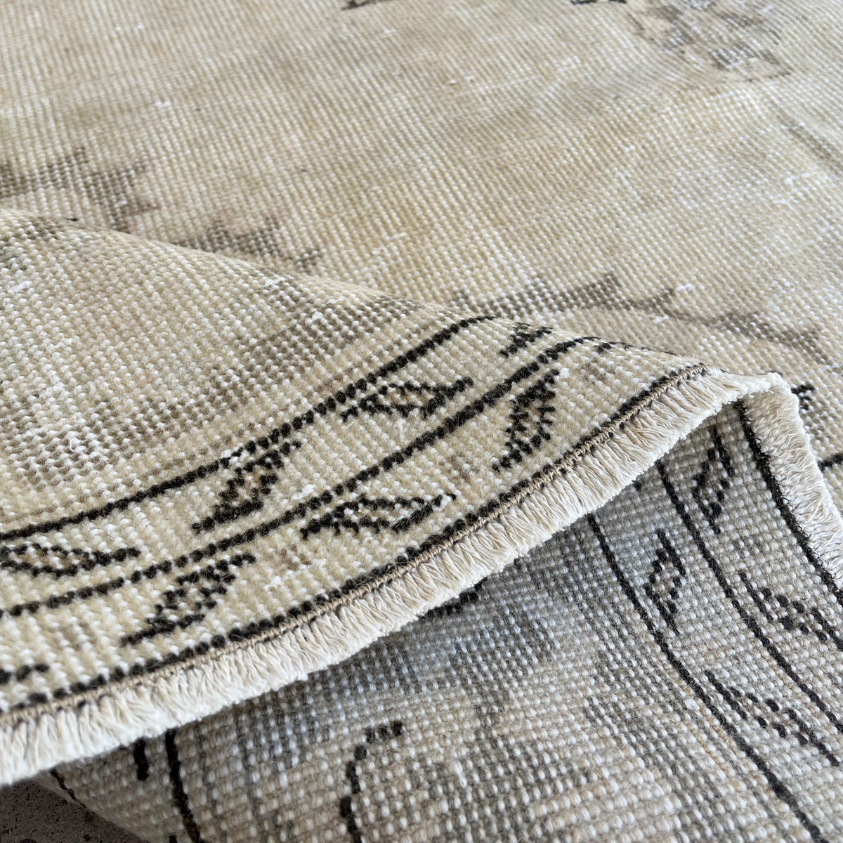 Close-up of the beige vintage Turkish medallion rug showing neutral details, hand-knotted weave, wool and cotton and low pile.