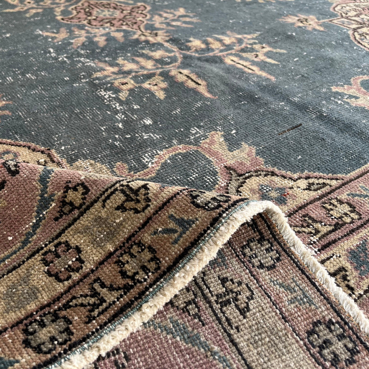 Close-up of the blue vintage Turkish medallion rug showing medallion details, hand-knotted weave, wool and cotton and low pile.