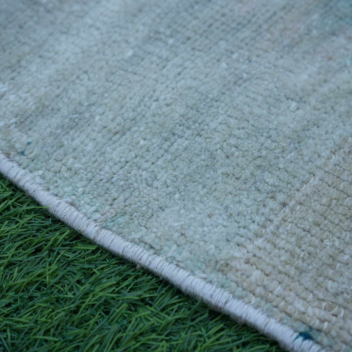 Beige 2' x 2' vintage Turkish mini rug in wool and cotton, shown on the floor.