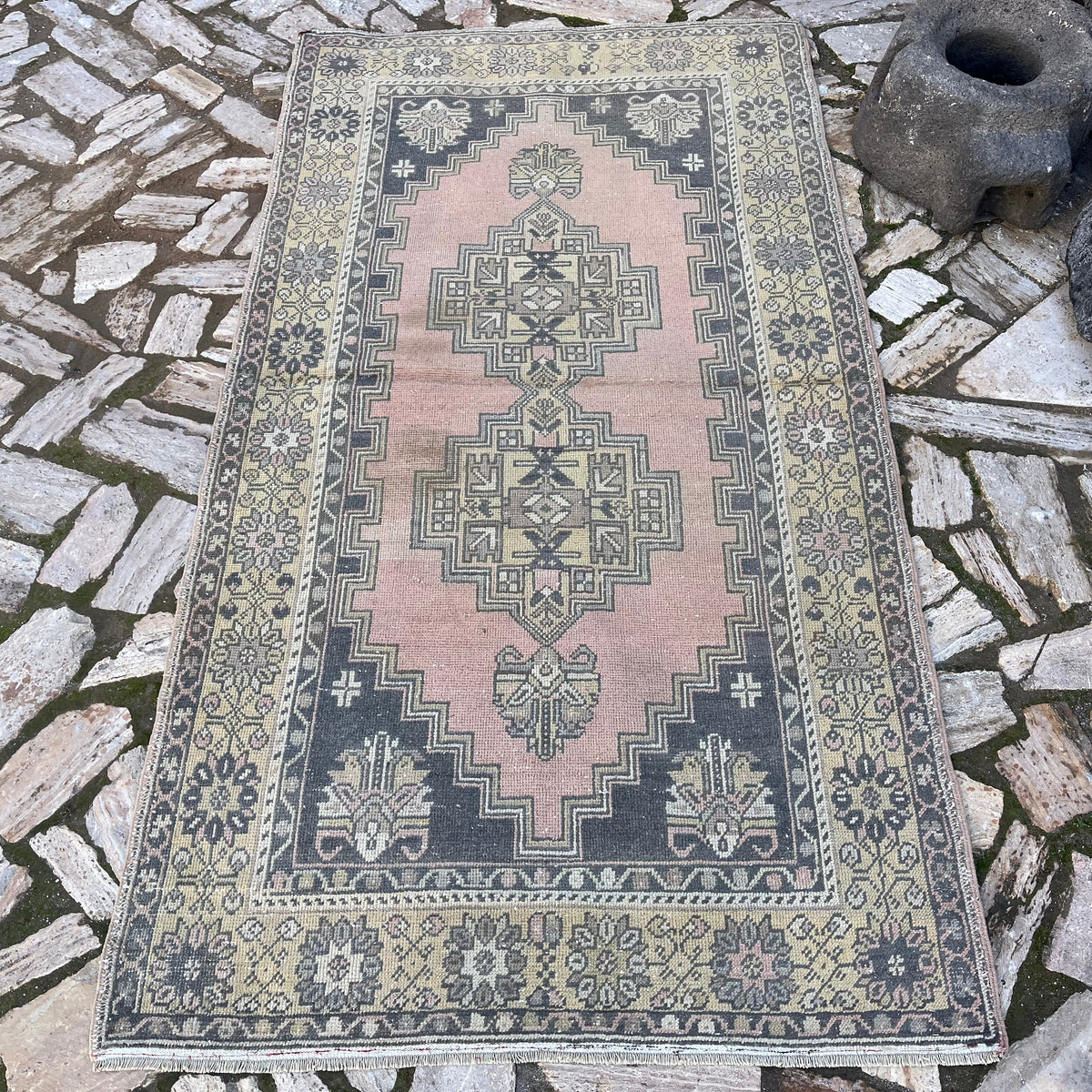 Pink 4' x 7' vintage Turkish oriental rug in wool and cotton, shown on the floor.