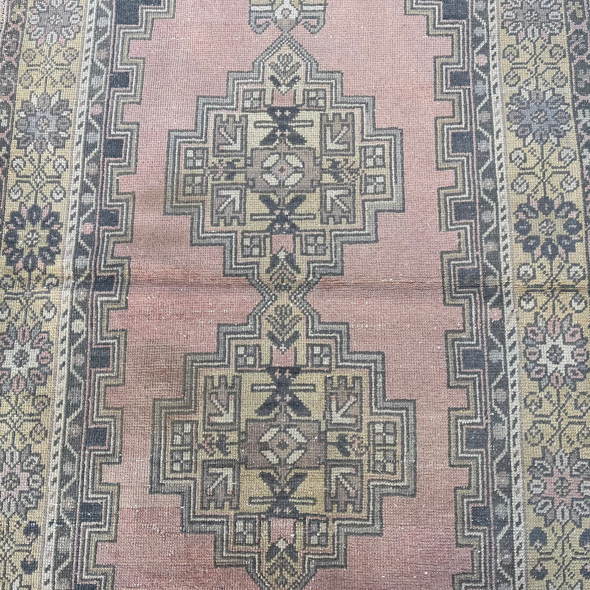 1970s pink vintage Turkish oriental rug with geometric design, hand-knotted weave and low pile.