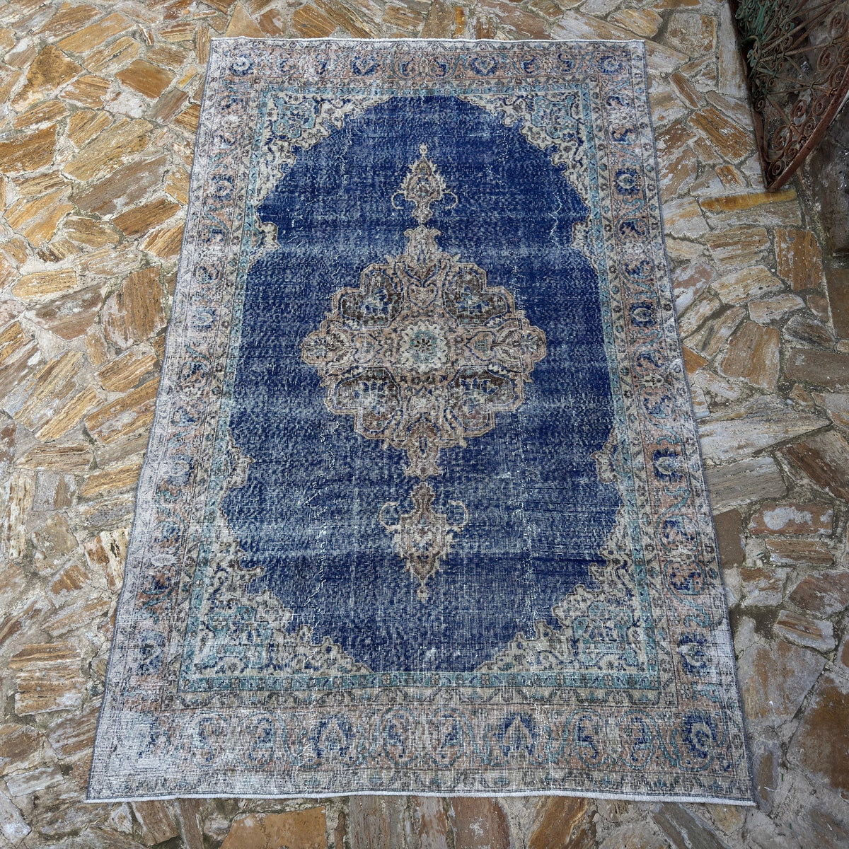 Blue 6' x 10' vintage Turkish oriental rug in wool and cotton, shown on the floor.
