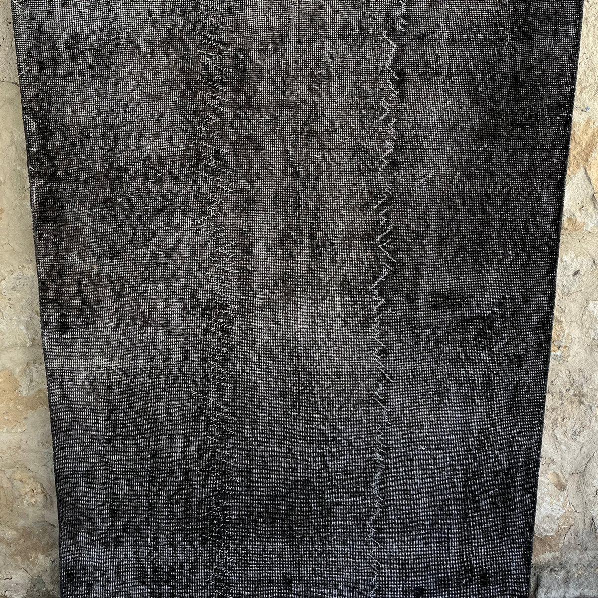 Black 4' x 10' vintage Turkish overdyed rug in wool and cotton, shown on the floor.