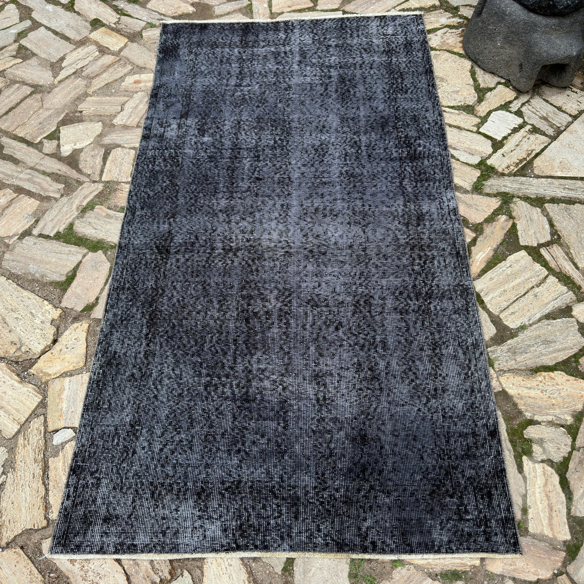 Black 4' x 7' vintage Turkish overdyed rug in wool and cotton, shown on the floor.
