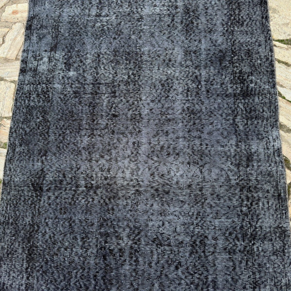 1970s black vintage Turkish overdyed rug, hand-knotted weave and low pile.