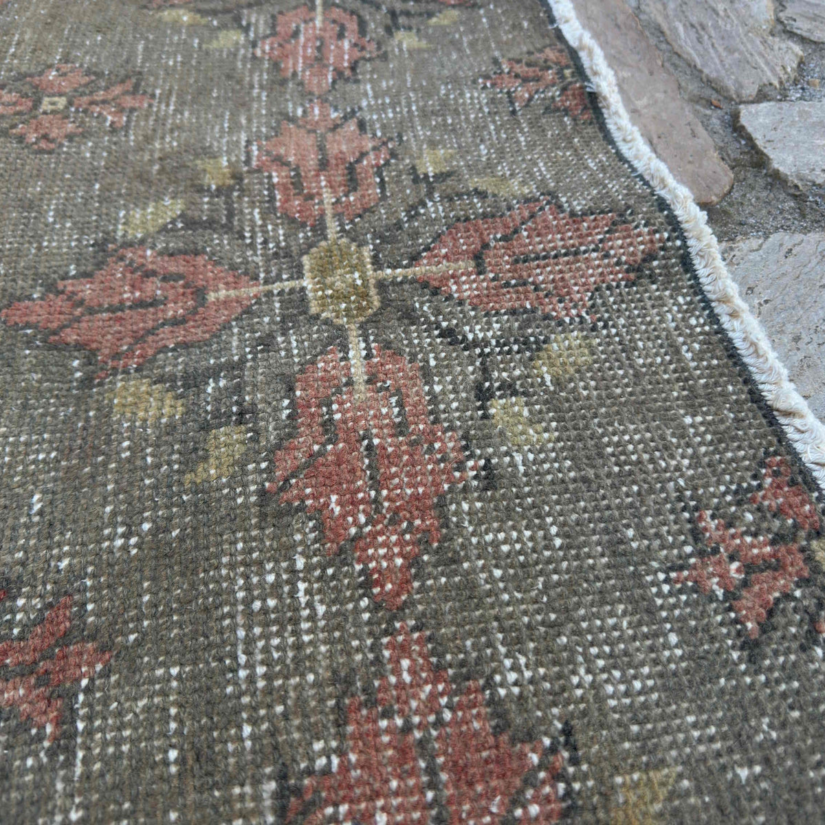 Close-up of the gray vintage Turkish overdyed rug showing traditional details, hand-knotted weave, wool and cotton and low pile.