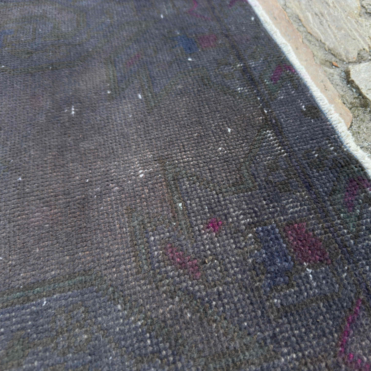 Close-up of the grey vintage Turkish overdyed rug showing overdyed details, hand-knotted weave, wool and cotton and low pile.