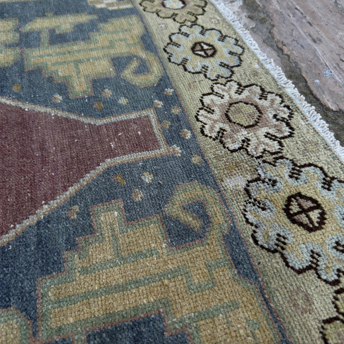 Close-up of the red vintage Turkish persian rug showing traditional details, hand-knotted weave, wool and cotton and low pile.