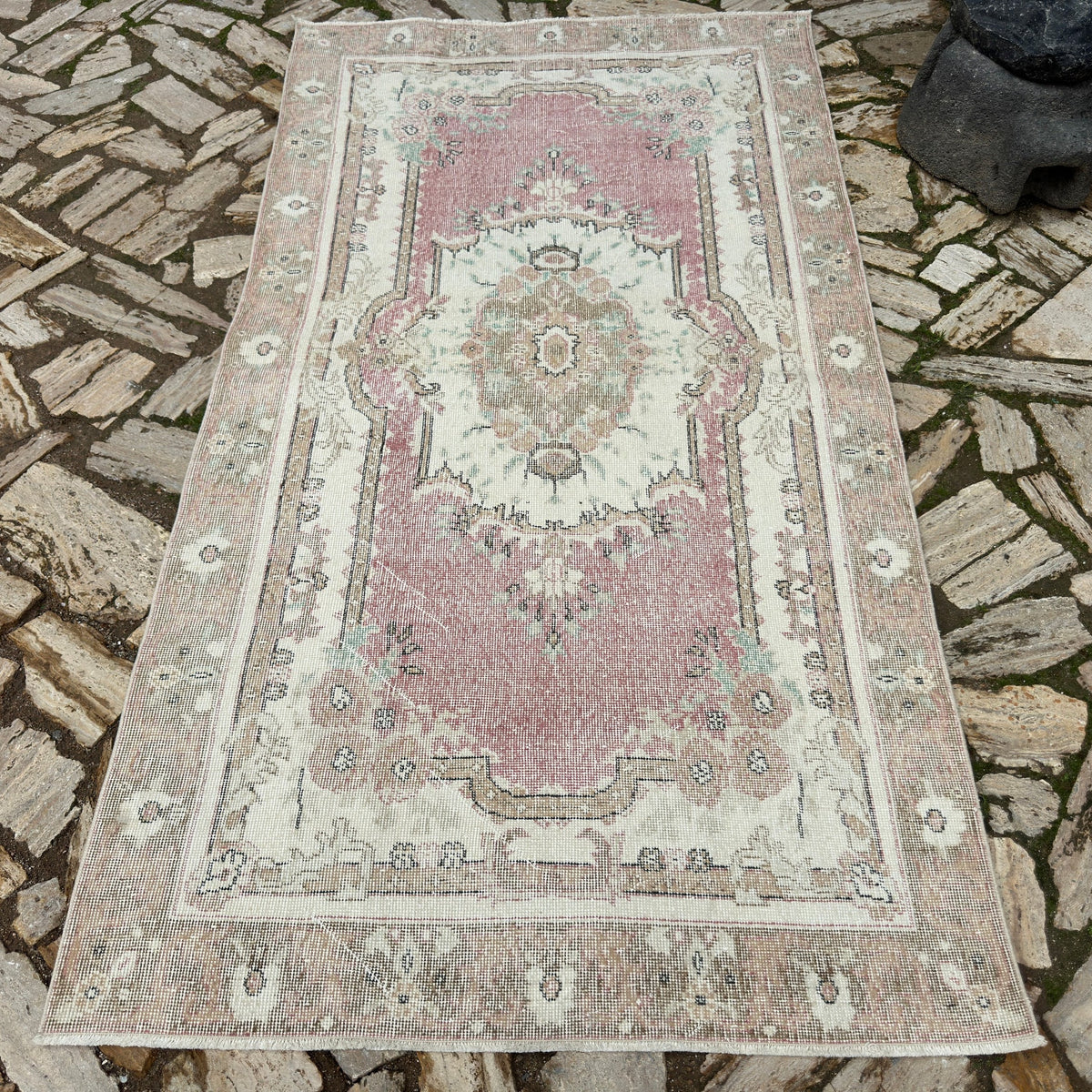 Pink 4' x 8' vintage Turkish persian rug in wool and cotton, shown on the floor.