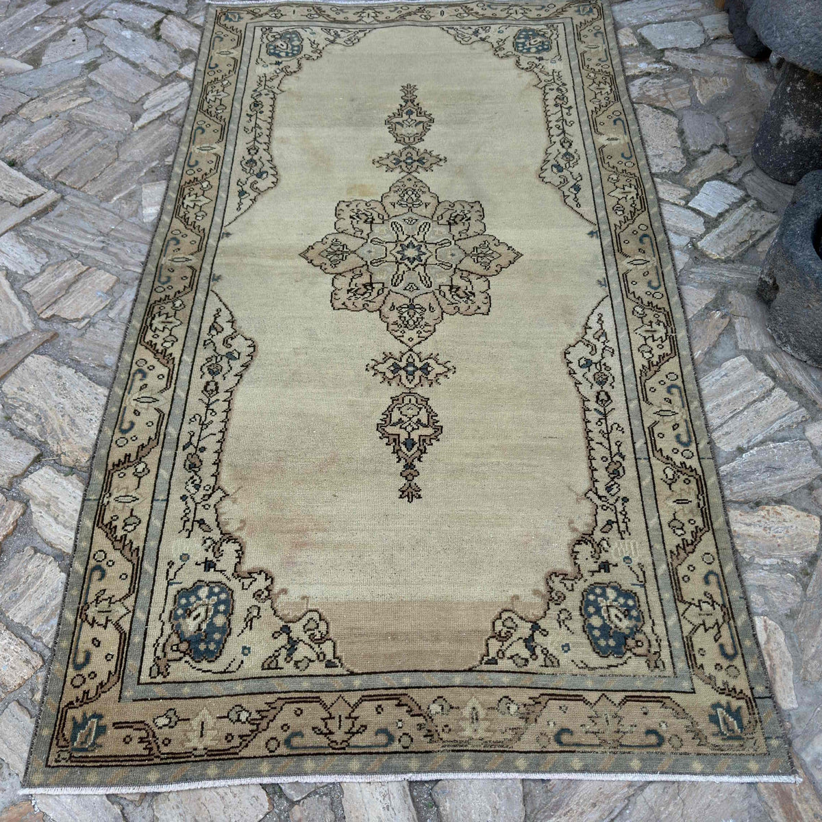 Beige 5' x 8' vintage Turkish persian rug in wool and cotton, shown on the floor.