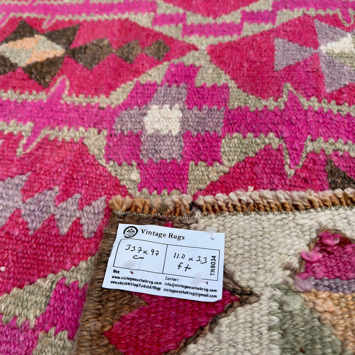 Close-up of the pink vintage persian runner rug showing traditional details, hand-knotted weave, wool and cotton and low pile.