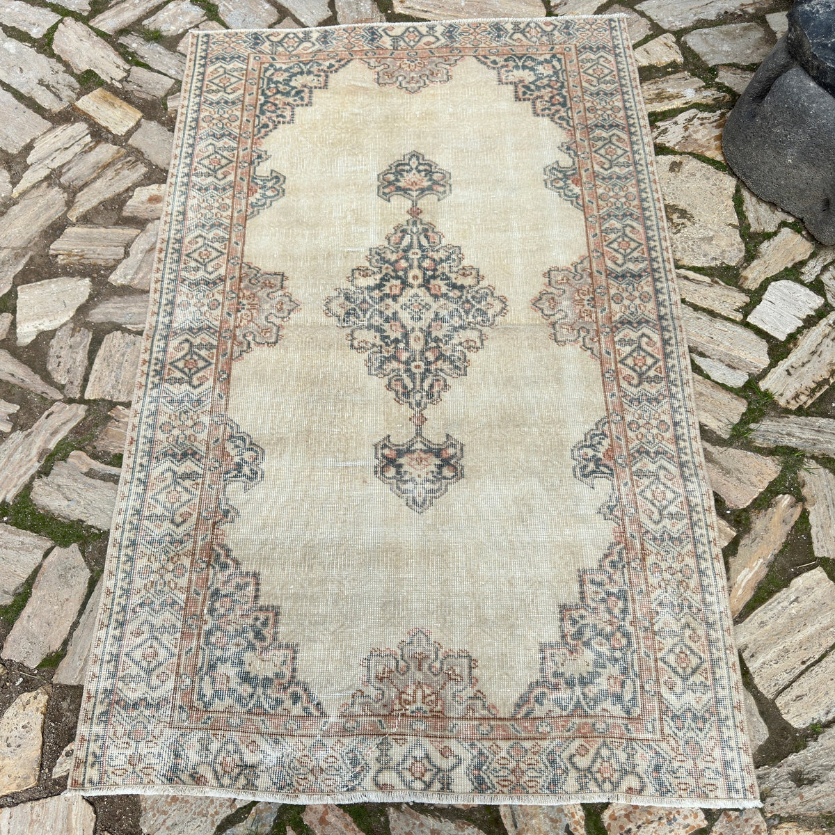 Beige 4' x 6' vintage Turkish persian style rug in wool and cotton, shown on the floor.