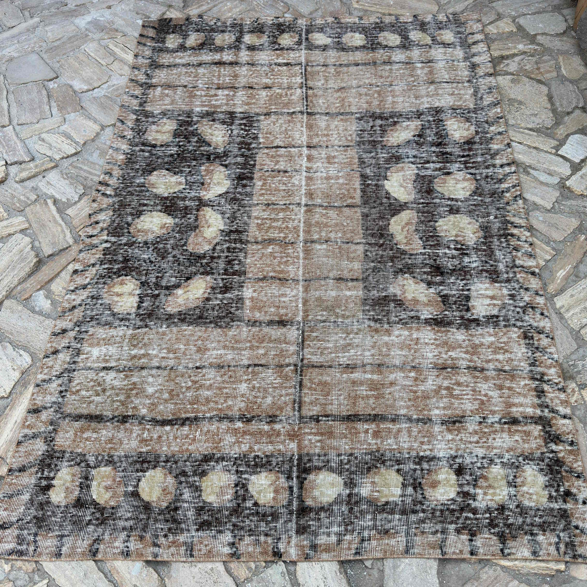 Brown 5' x 8' vintage Turkish persian style rug in wool and cotton, shown on the floor.