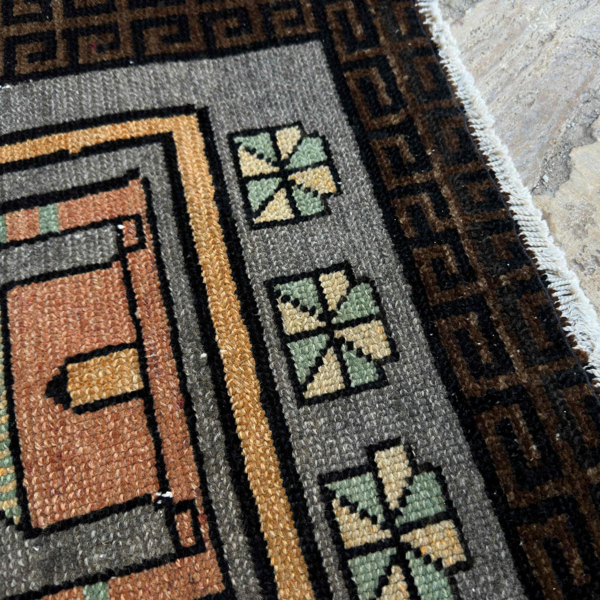 Close-up of the gray vintage Turkish prayer rug showing traditional details, hand-knotted weave, wool and cotton and low pile.