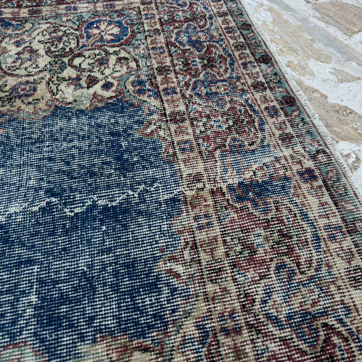 Close-up of the blue vintage Turkish rug showing medallion details, hand-knotted weave, wool and cotton and low pile.