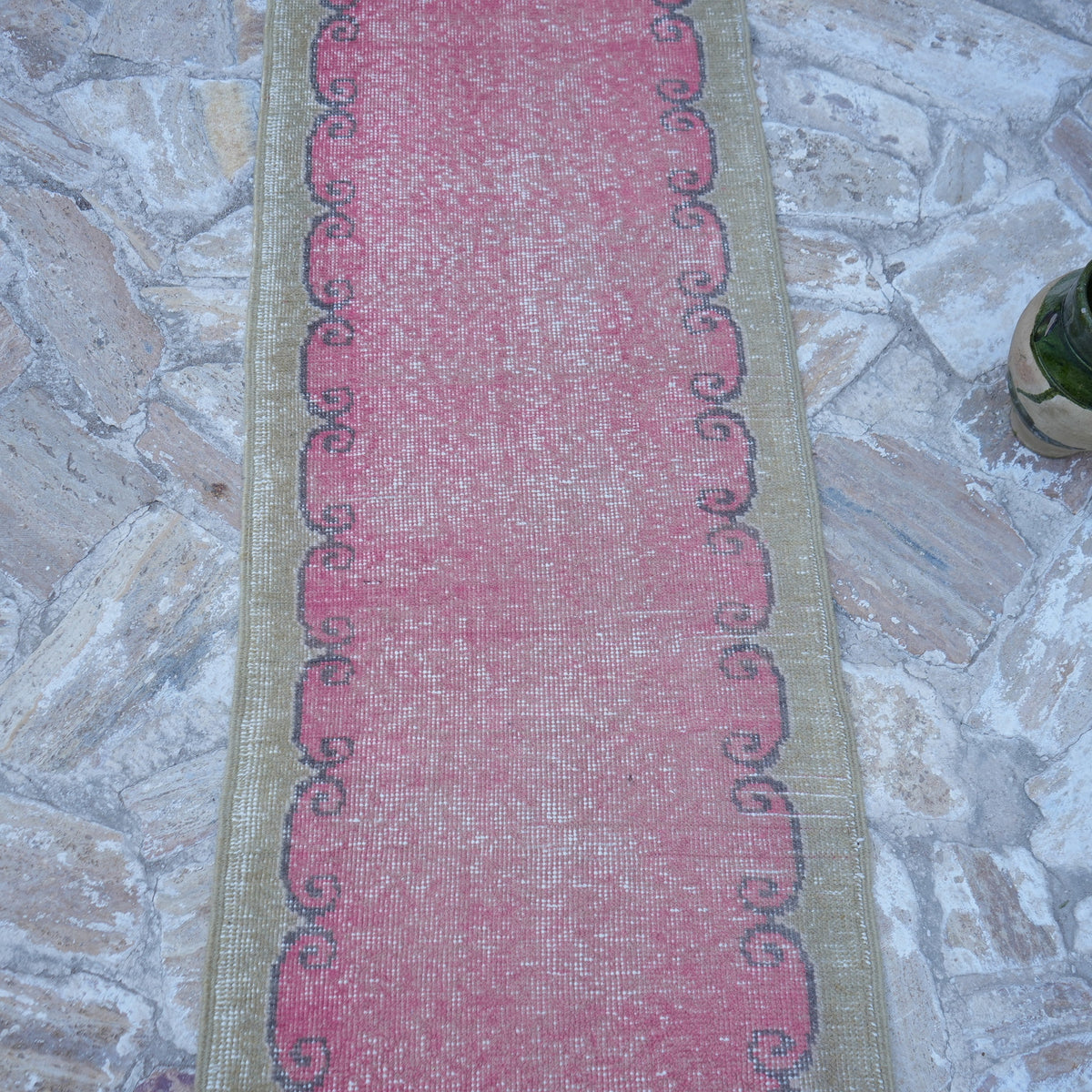 Close-up of the pink vintage Turkish runner rug showing traditional details, hand-knotted weave, wool and cotton and low pile.
