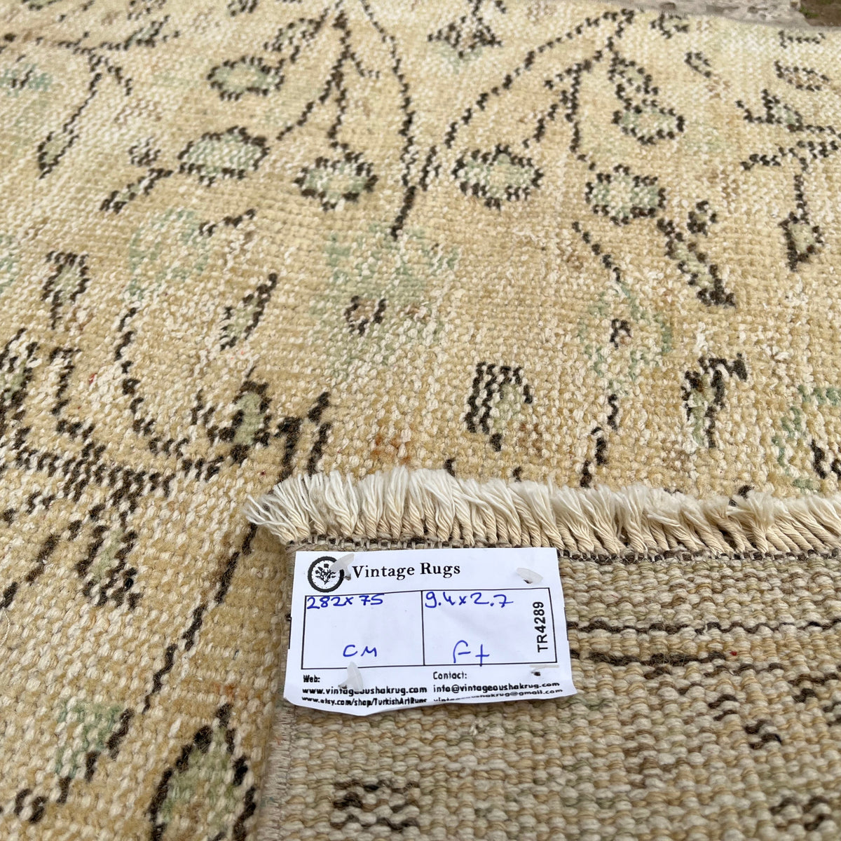 Close-up of the beige vintage Turkish runner rug showing floral details, hand-knotted weave, wool and cotton and low pile.