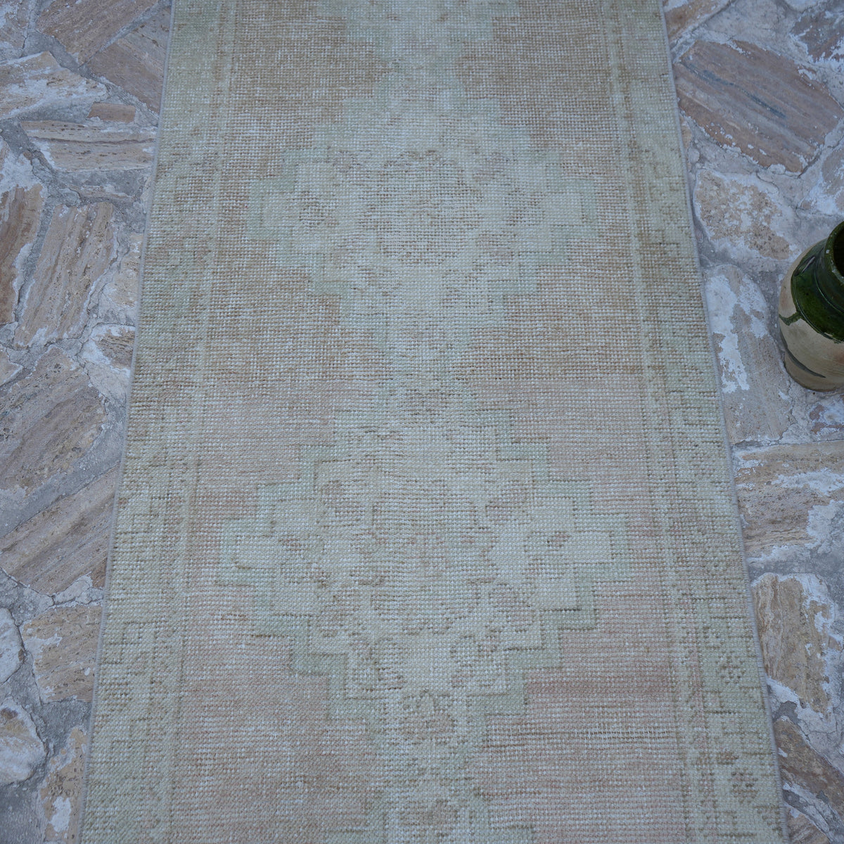 Close-up of the pink vintage Turkish runner rug showing traditional details, hand-knotted weave, wool and cotton and low pile.