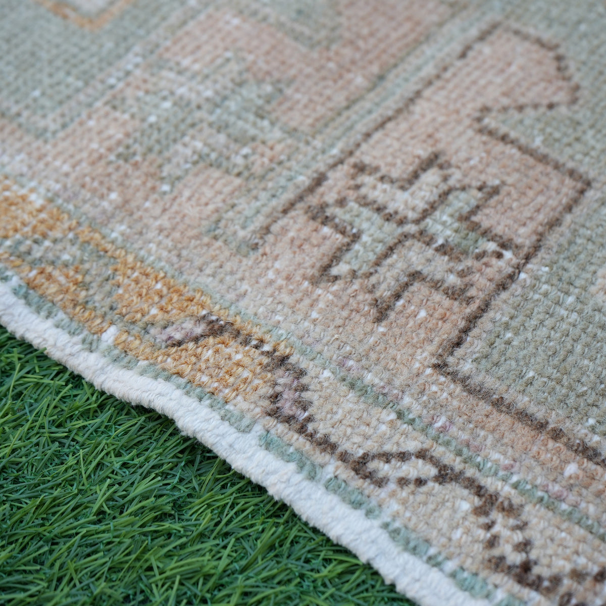 Pink 2' x 3' vintage Turkish small rug in wool and cotton, shown on the floor.