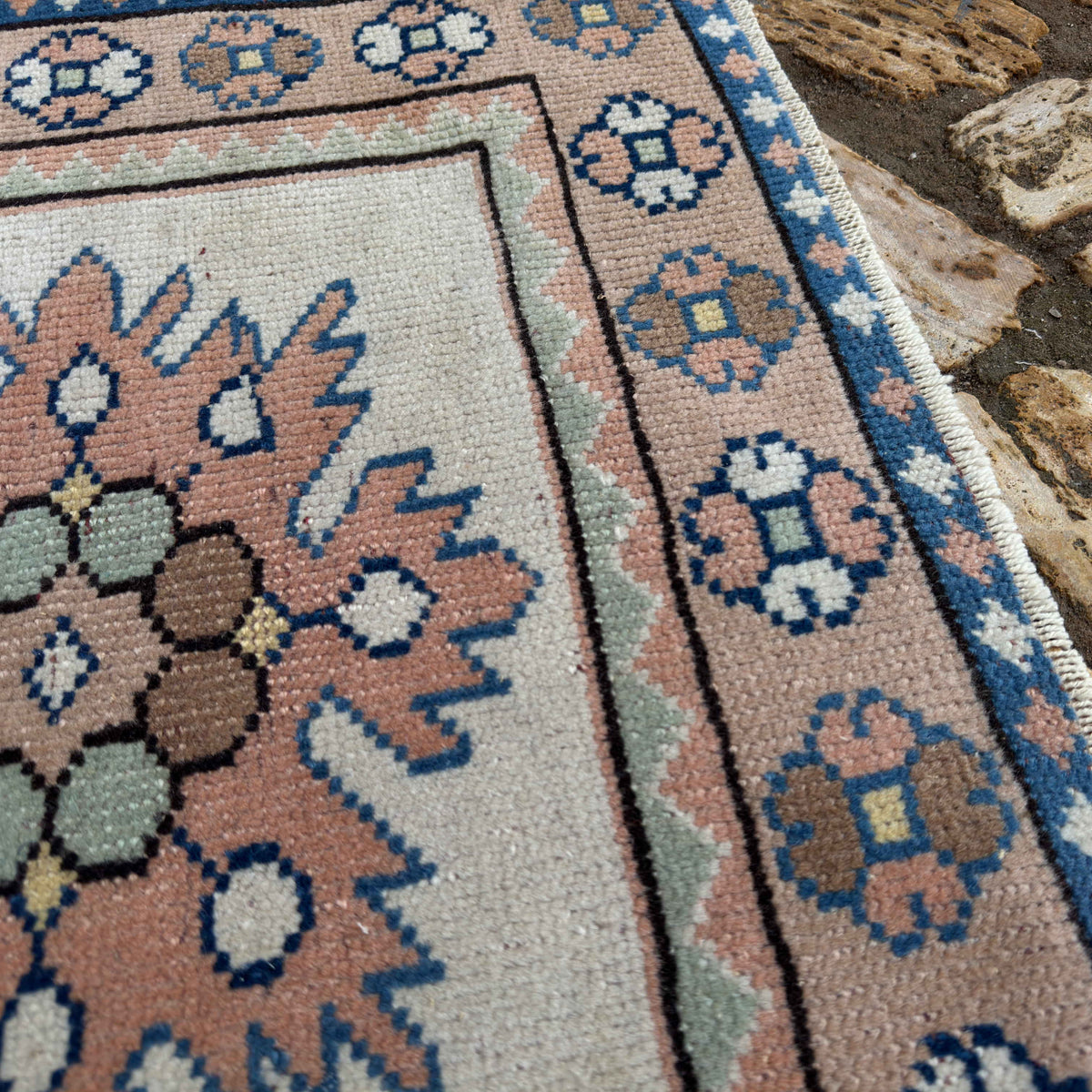 Close-up of the beige vintage Turkish small rug showing traditional details, hand-knotted weave, wool and cotton and low pile.