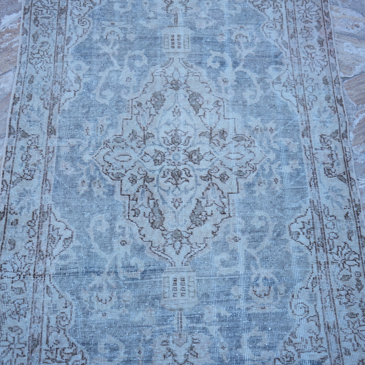 Close-up of the blue vintage Turkish traditional rug showing traditional details, hand-knotted weave, wool and cotton and low pile.