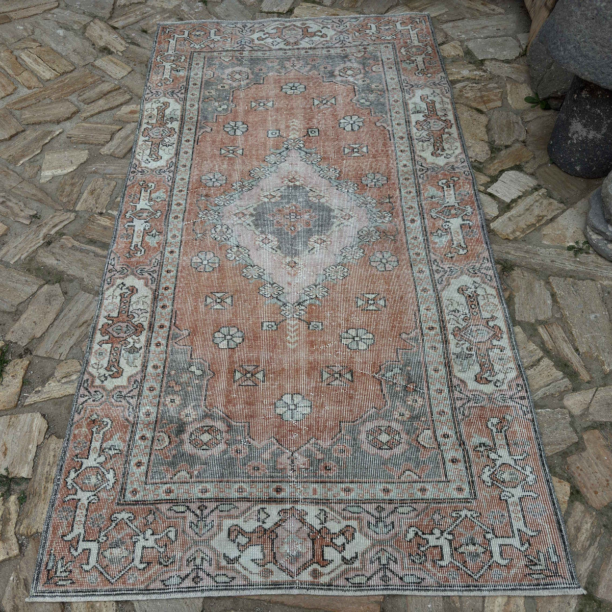 Pale Orange 4' x 7' vintage Turkish traditional rug in wool and cotton, shown on the floor.
