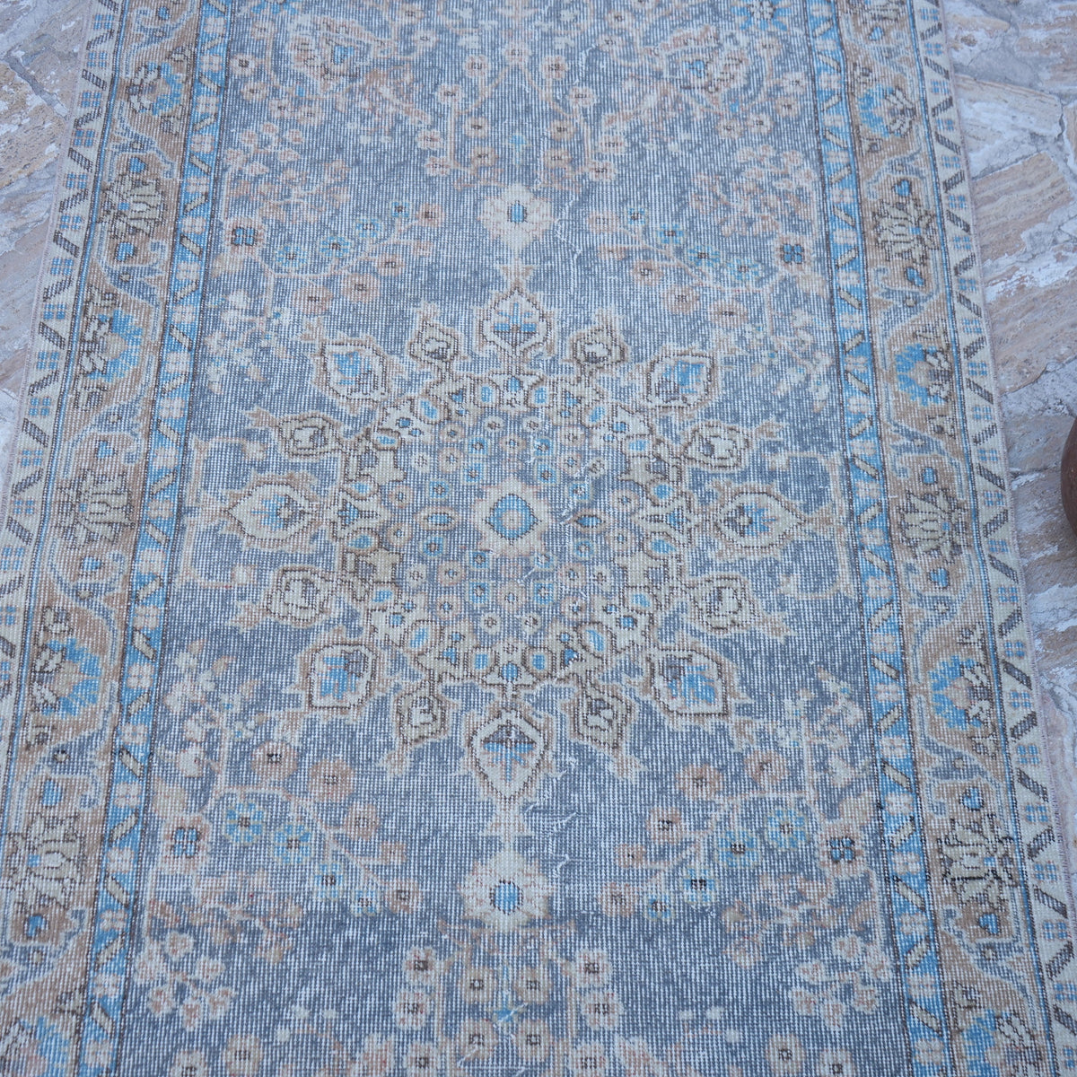 Close-up of the purple vintage Turkish traditional rug showing traditional details, hand-knotted weave, wool and cotton and low pile.
