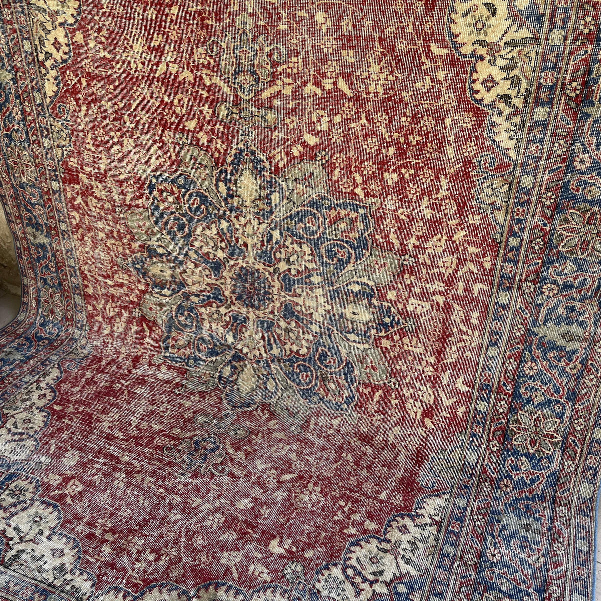 Red 7' x 10' vintage Turkish traditional rug in wool and cotton, shown on the floor.