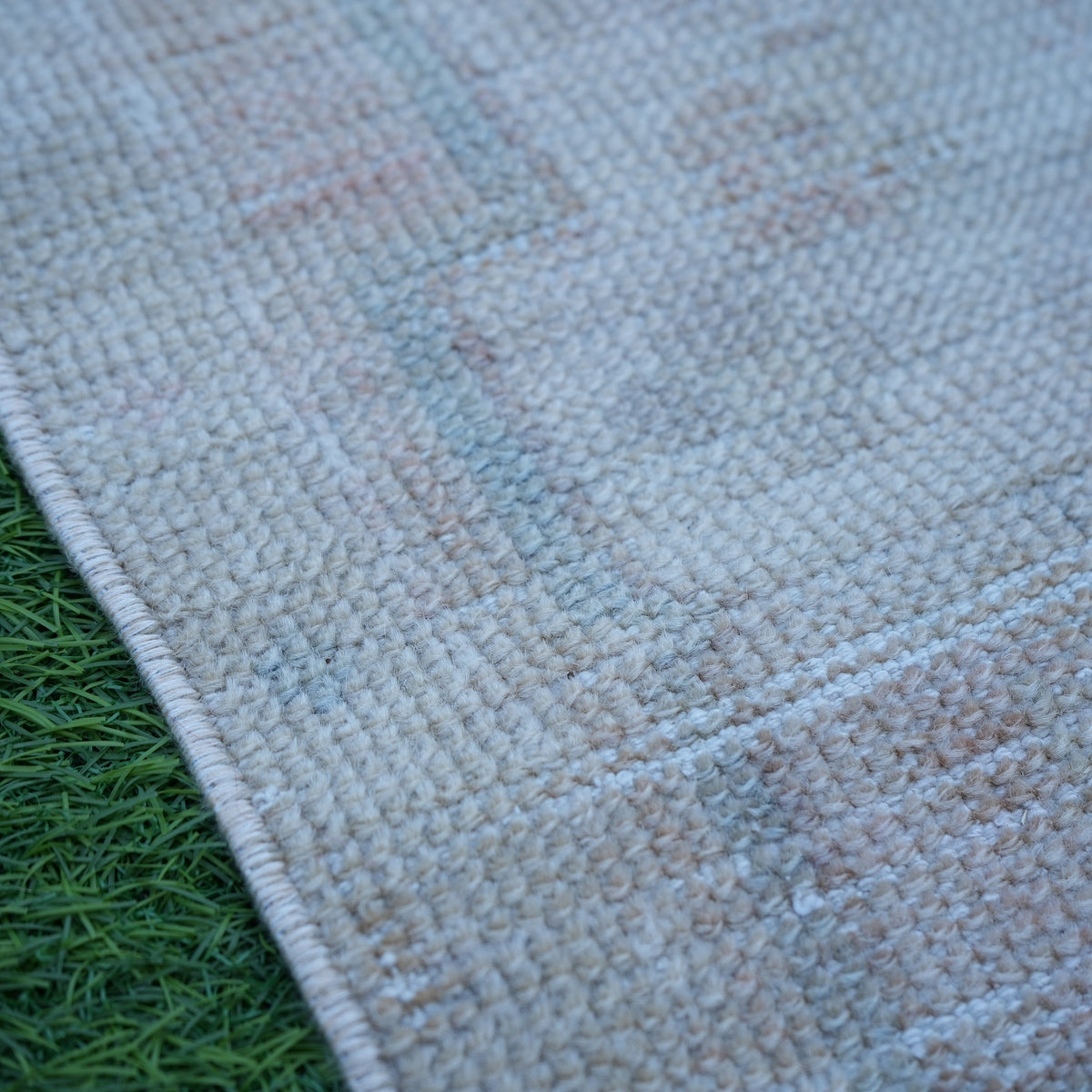 Beige 1' x 3' vintage turkish rug in wool and cotton, shown on the floor.