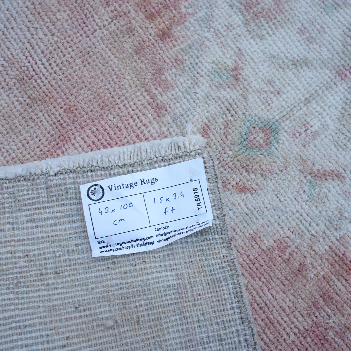 Pale Red 1' x 3' vintage turkish rug from the 1970s with neutral design.
