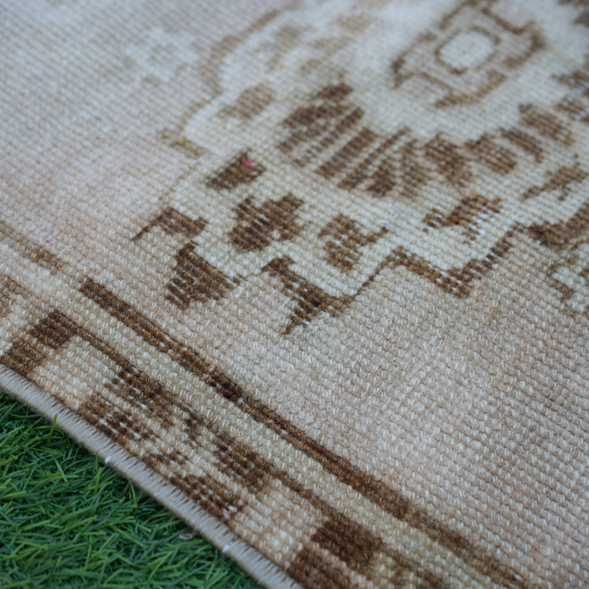 Beige 2' x 3' vintage turkish rug in wool and cotton, shown on the floor.