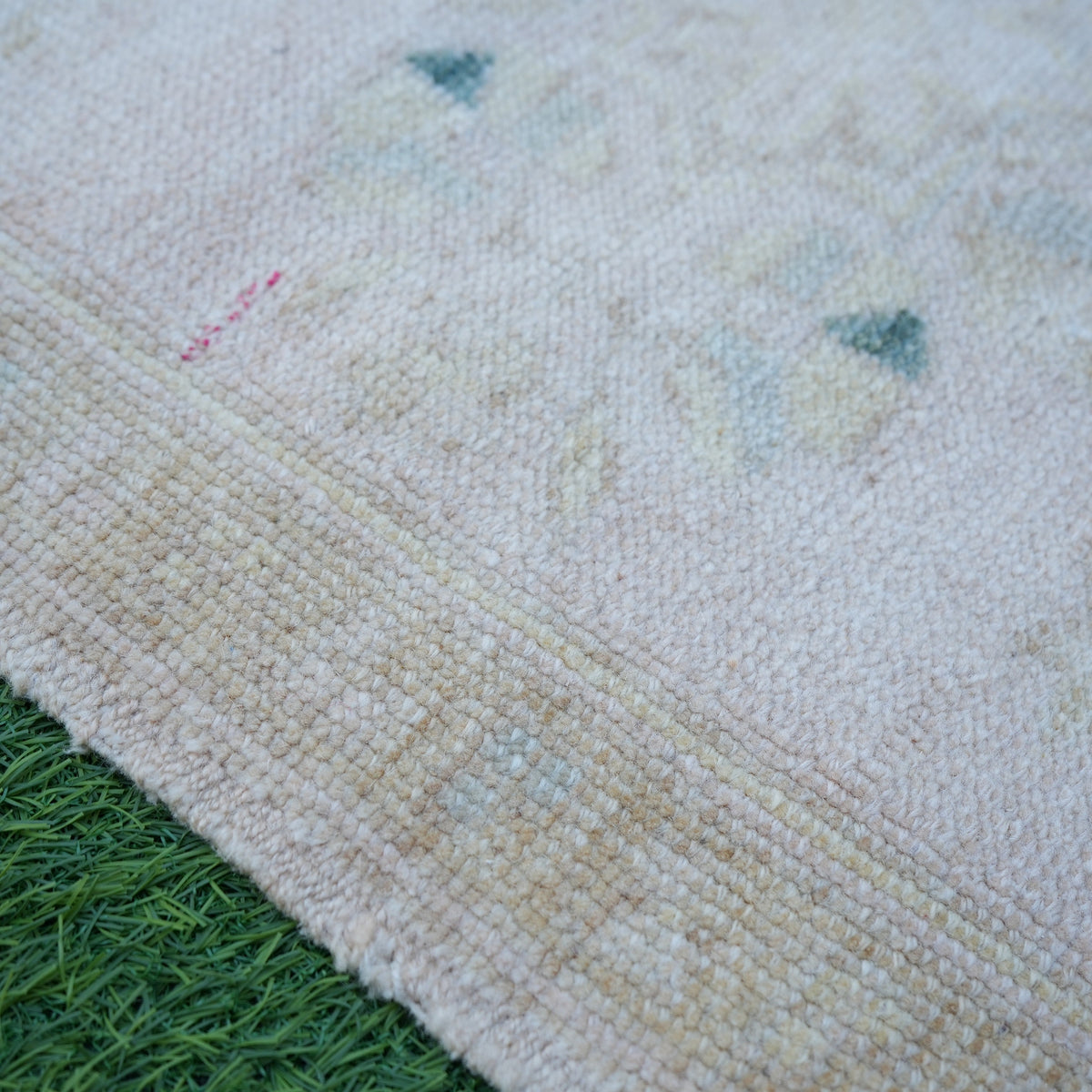 Beige 2' x 3' vintage turkish rug in wool and cotton, shown on the floor.