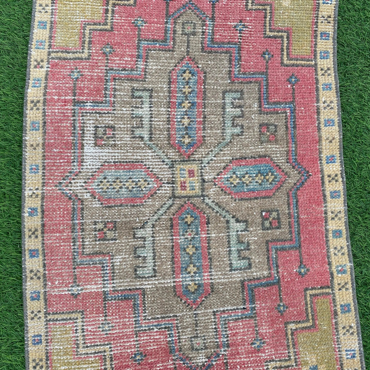1970s pink vintage turkish rug with geometric design, hand-knotted weave and low pile.