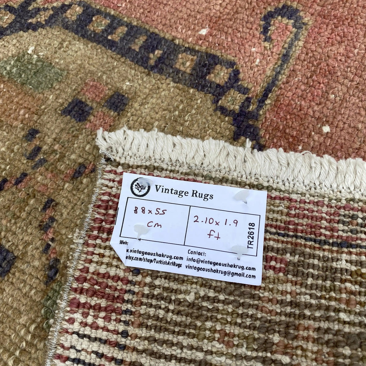 Close-up of the pink vintage turkish rug showing geometric details, hand-knotted weave, wool and cotton and low pile.