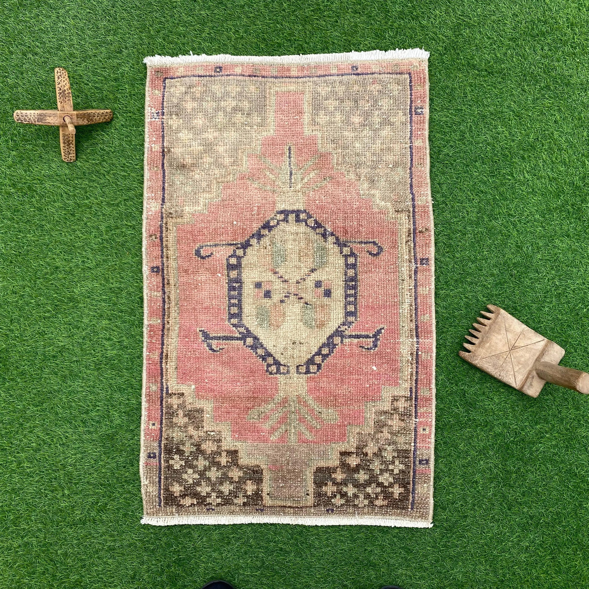 Pink 2' x 3' vintage turkish rug in wool and cotton, shown on the floor.