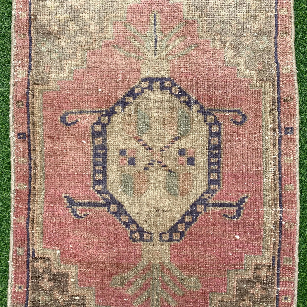 1970s pink vintage turkish rug with geometric design, hand-knotted weave and low pile.