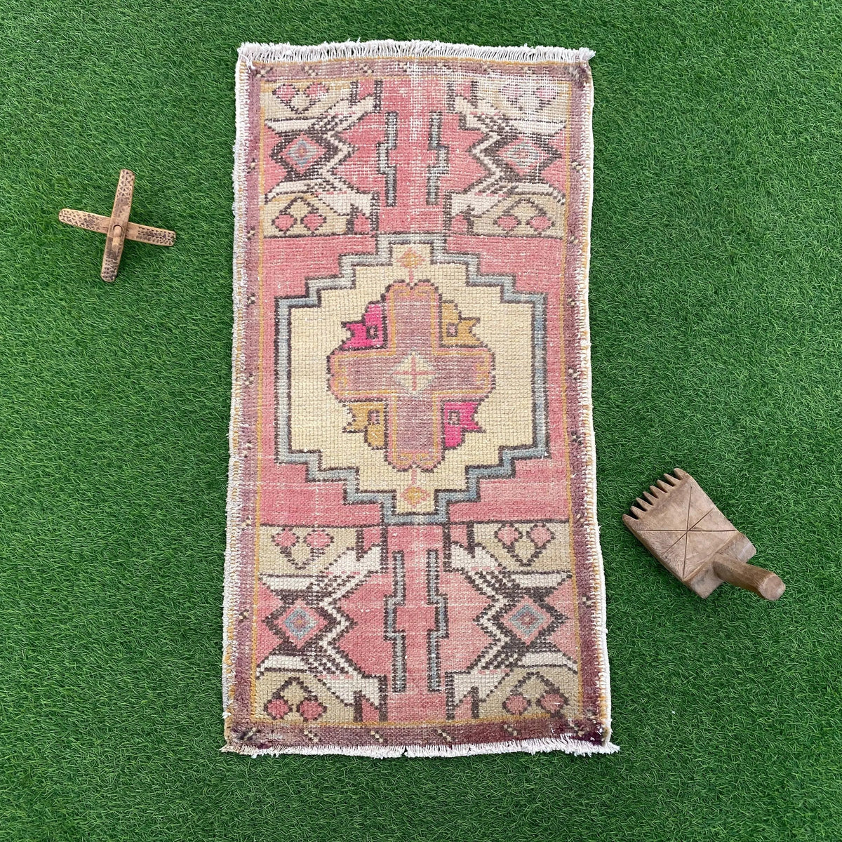 Pink 2' x 3' vintage turkish rug in wool and cotton, shown on the floor.