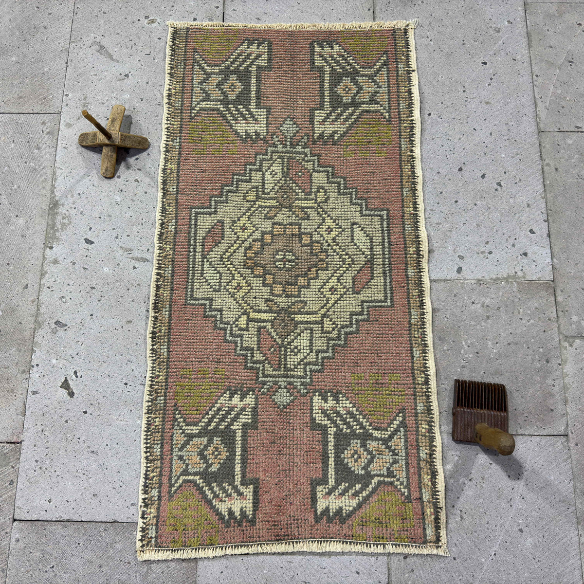 Pink 2' x 3' vintage turkish rug in wool and cotton, shown on the floor.