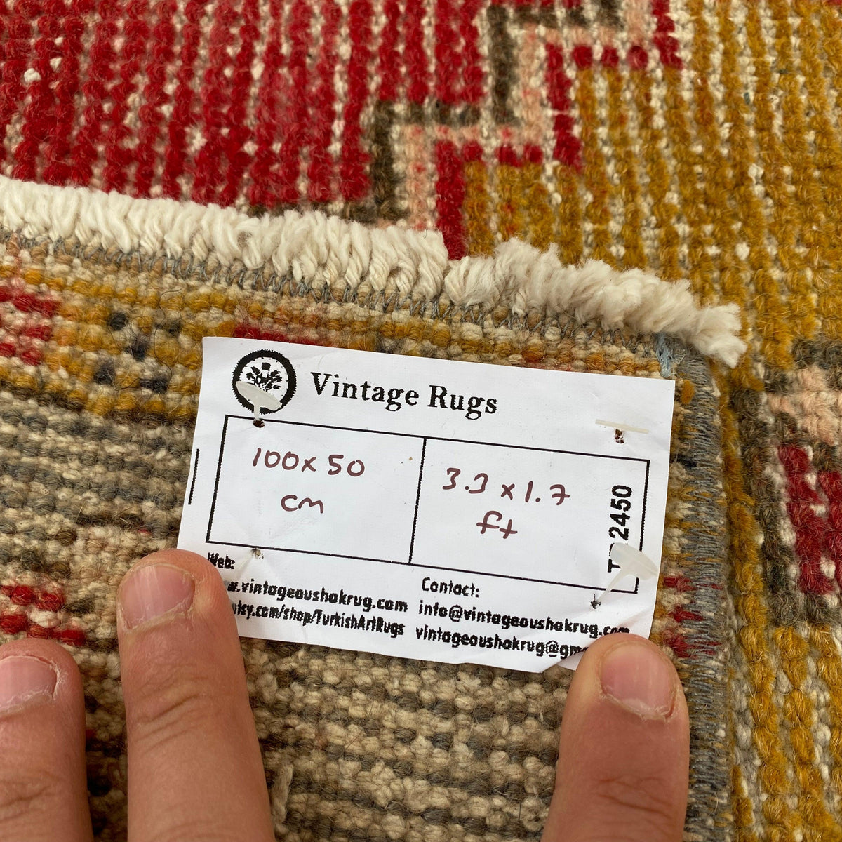 Close-up of the red vintage turkish rug showing traditional details, hand-knotted weave, wool and cotton and low pile.