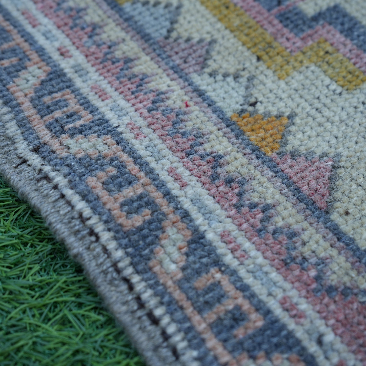 Pink 2' x 4' vintage turkish rug in wool and cotton, shown on the floor.