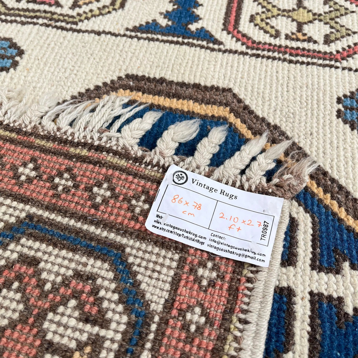 Close-up of the red vintage turkish rug showing geometric details, hand-knotted weave, wool and cotton and low pile.